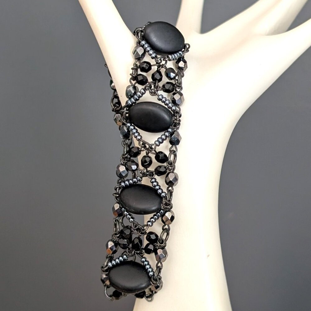 Dark gray and black beaded bracelet with black oval smooth center beads